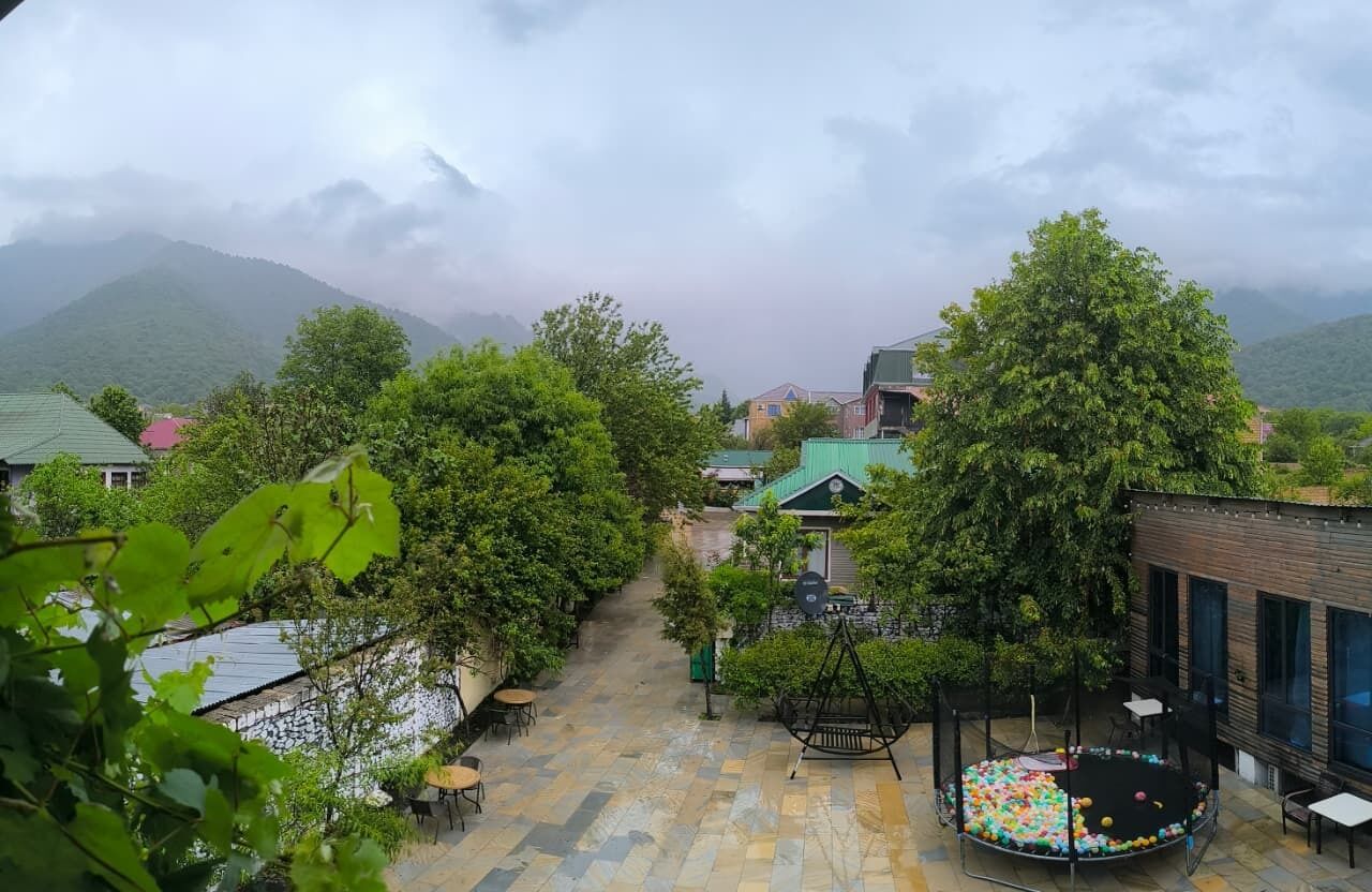 A courtyard with a play area, seating, and a view of mountains.