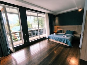 A bedroom with a large window, a bed, and a wooden floor. - Fortuna Boutique Hotel & Restaurant (Gabala)