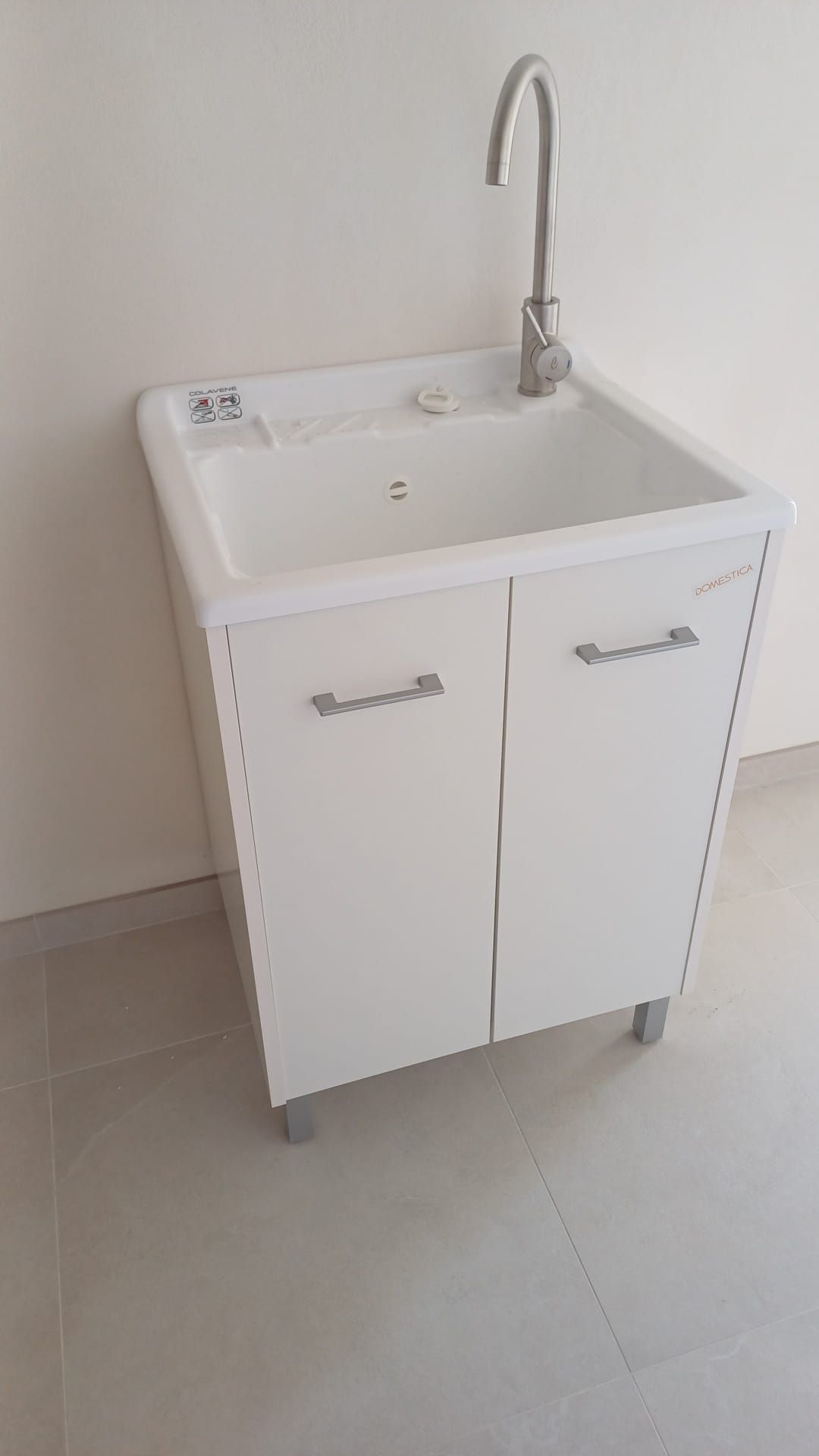 Ein weißes, tragbares Waschbecken mit Armatur, zwei Schubladen und einer kleinen Ablagefläche.