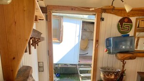 Un interno in legno con un tavolo, una lampada a sospensione e vista sull'esterno.