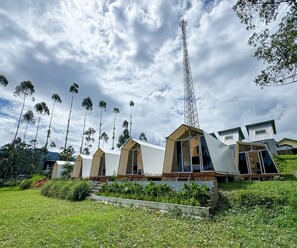 A row of modern, uniquely shaped cabins with large windows, surrounded by lush greenery and tall trees. - Cozzy Talaga Artea Pangalengan (bandung)