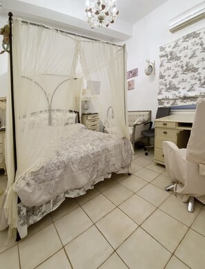 Un dormitorio con cama con dosel, un escritorio, una silla y un reloj de pared.