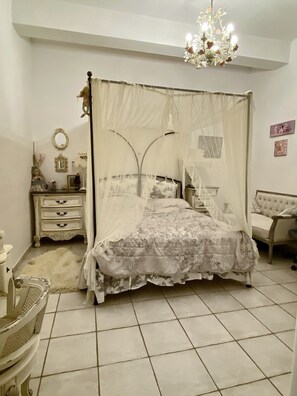 A bedroom with a canopy bed, a dresser, a chair, and a chandelier. - Mykonos Cycladic house
The perfect White House , near panormos beach (Mykonos)