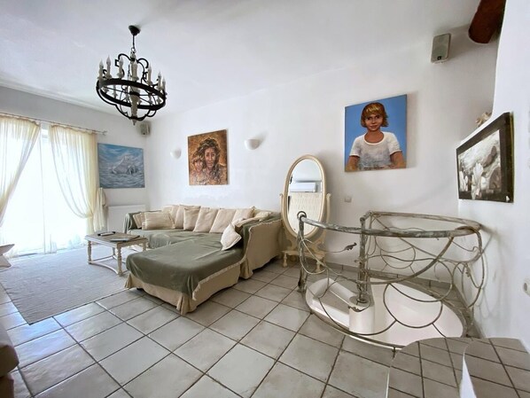 Un dormitorio con cama, candelabro, espejo y obras de arte en las paredes.