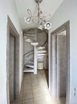 A spiral staircase with white railings and a chandelier with white flowers. - Mykonos Cycladic house
The perfect White House , near panormos beach (Mykonos)