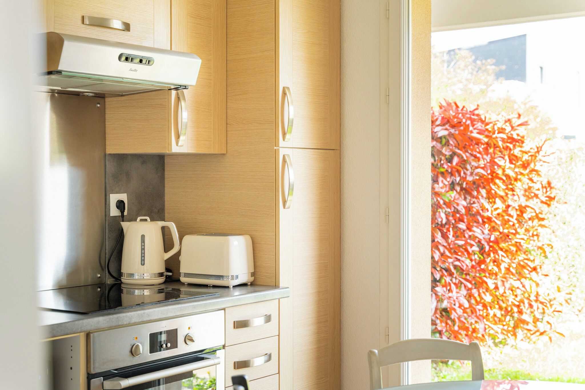A kitchen with a built-in oven, a coffee maker, and a toaster on the countertop.