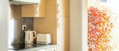 A kitchen with a built-in oven, a coffee maker, and a toaster on the countertop.