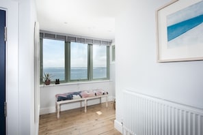 A room with a bench, a radiator, and a large window with a view of the sea. - Mermaids 3 - Sea-facing property, direct beach access (St Ives)