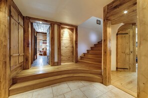 A wooden interior with a curved staircase, a hallway, and a door leading to another room. - Chalet La Bouclia - Luxury Alpine retreat (Val-d'Isère)