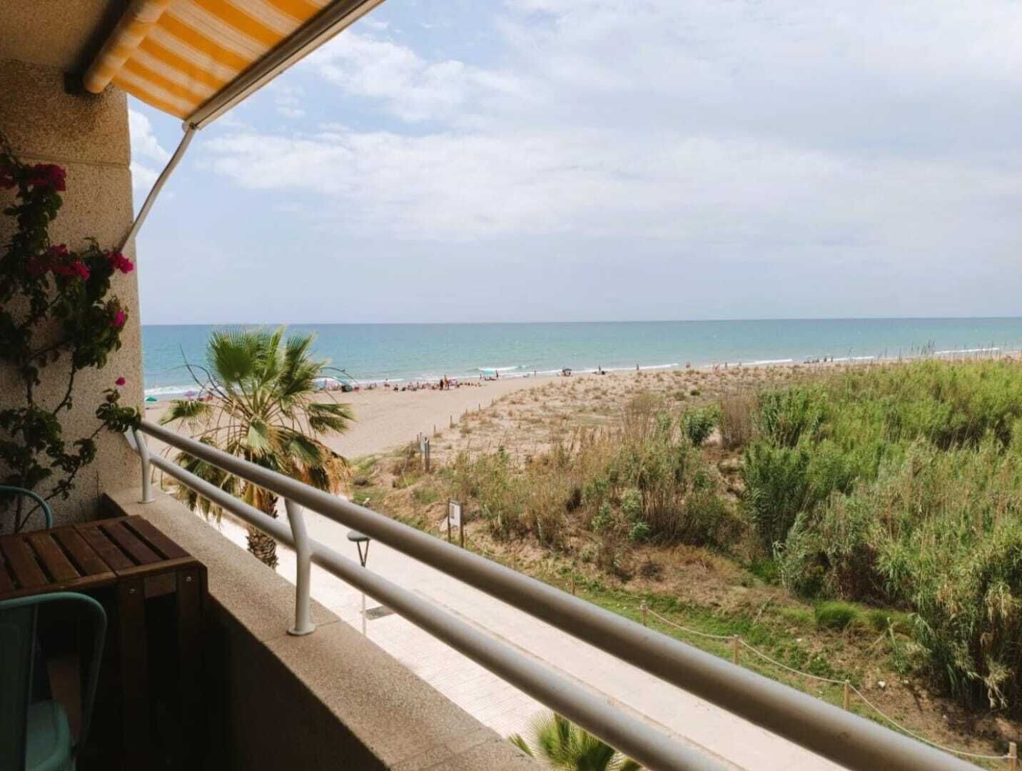 A balcony with a view of a beach and ocean.