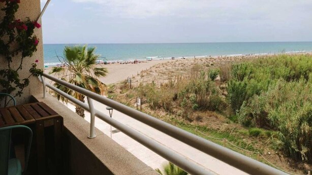 A balcony with a view of a beach and ocean. - Beachfront Apartment with Sea-View Terrace (Calafell)