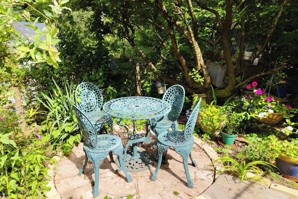 A garden patio with a round table and four chairs. - Tranquil Woodland Cottage by River Wye (Lydbrook)