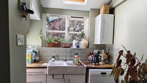 Una cocina con ventana, pileta, alacenas y lavavajillas Bosch.