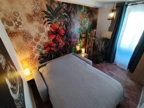 A room with a bed, a wall mural, a nightstand with a lamp, and a window with curtains. - Country house, pets welcome - 6 guests (Tavers)