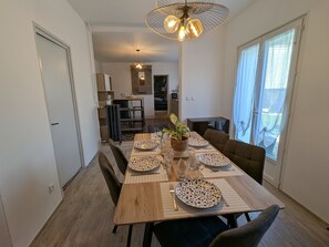 A dining area with a wooden table set for four, a potted plant, and a ceiling fan. - Country house, pets welcome - 6 guests (Tavers)