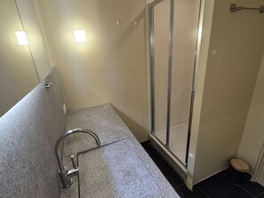 Ein Badezimmer mit Dusche, Waschbecken und Toilette.