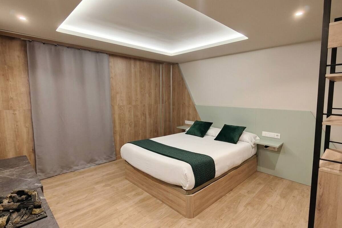 Un dormitorio moderno con una cama, una mesita de noche, un estante en la pared y una lámpara en el techo.