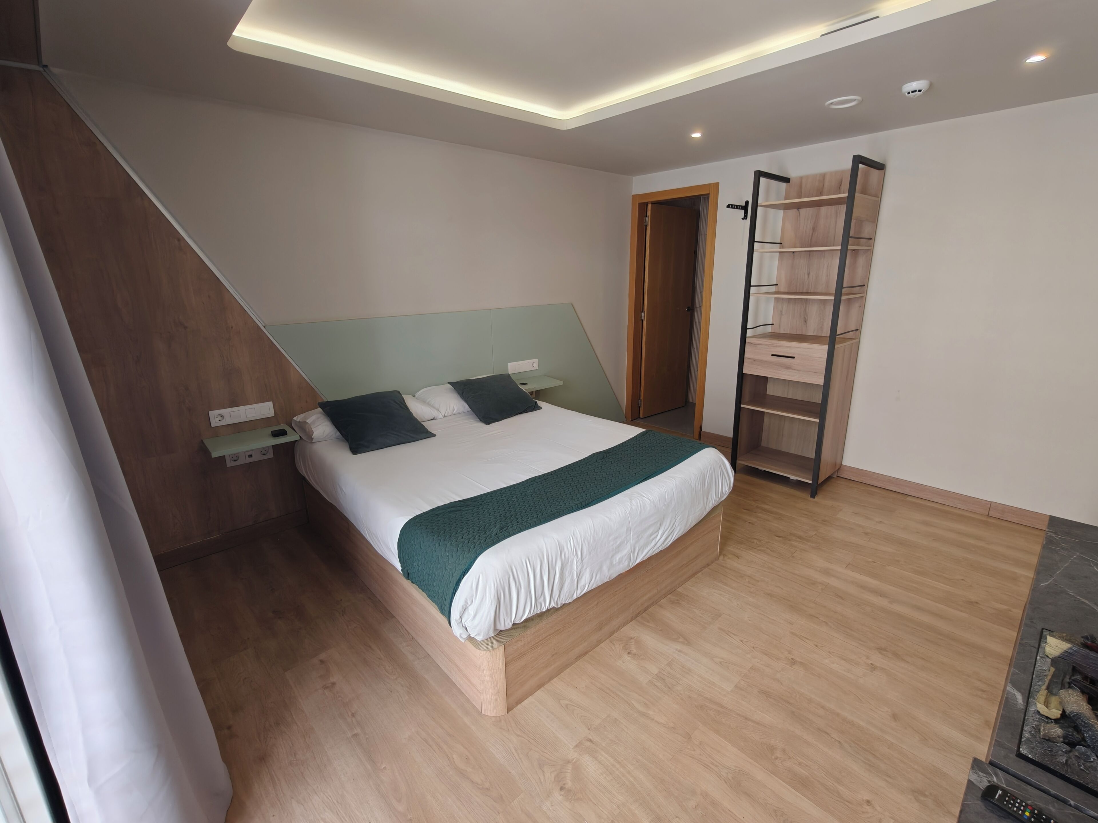Un dormitorio moderno con cama, mesitas de noche, un armario y una escalera.