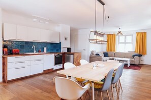 Eine moderne Küche mit weißen Schränken, einer Holz Arbeitsplatte und einem eingebauten Backofen.