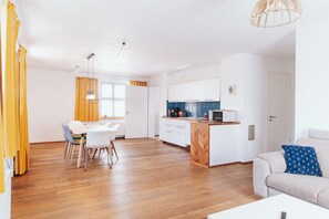 A modern apartment with a dining area, kitchen, and living space. - Backhus Vacation Home: Country House with Garden. Ideal for large families (Mellenthin)