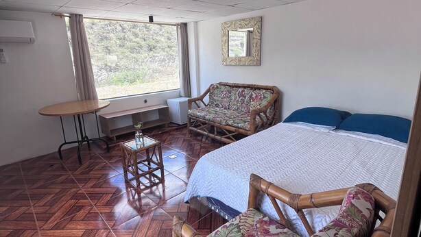 A room with a bed, a chair, a table, and a window. - "Sleeping Woman" Accommodation (Ambuquí)