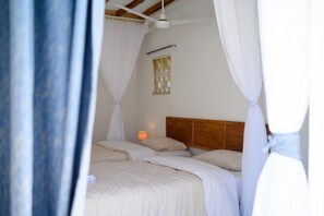 Un dormitorio con cabecera de madera, lámpara de noche y ventana con vistas.