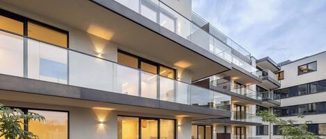 A modern multi-story building with balconies and large windows.