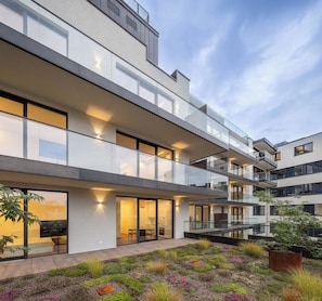 Un immeuble moderne à plusieurs étages, doté de balcons et de grandes fenêtres.