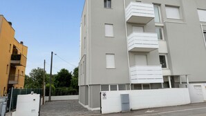 A multi-story residential building with balconies, a gated entrance, and a clear sky. - SE276 - Senigallia, elegant apartment with a/c close to all main services (Senigallia)