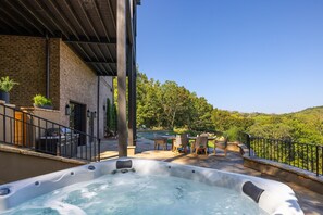 A hot tub on a patio with a view of a pool and trees. - Above Nashville Tranquility | Pool & Spa | 10 Acres | Gated (Nolensville)