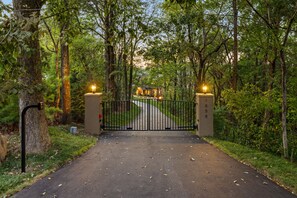 A gated entrance to a property surrounded by trees. - Above Nashville Tranquility | Pool & Spa | 10 Acres | Gated (Nolensville)