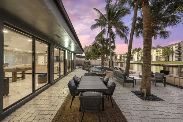 Eine moderne Außenpatio mit Pool, Liegestühlen und Essbereich.