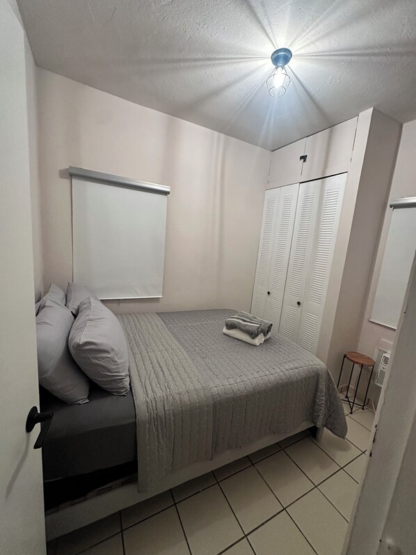 A bedroom with a bed, a wardrobe, a radiator, and a ceiling light. - 2-bedroom apartment in beautiful San Juan with AC (San Juan)