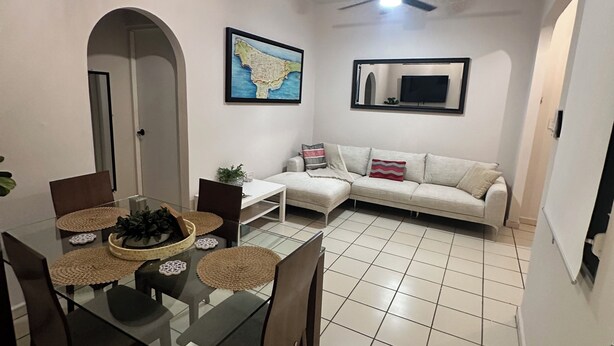 A dining area with a glass table, chairs, and a map on the wall. - 2-bedroom apartment in beautiful San Juan with AC (San Juan)