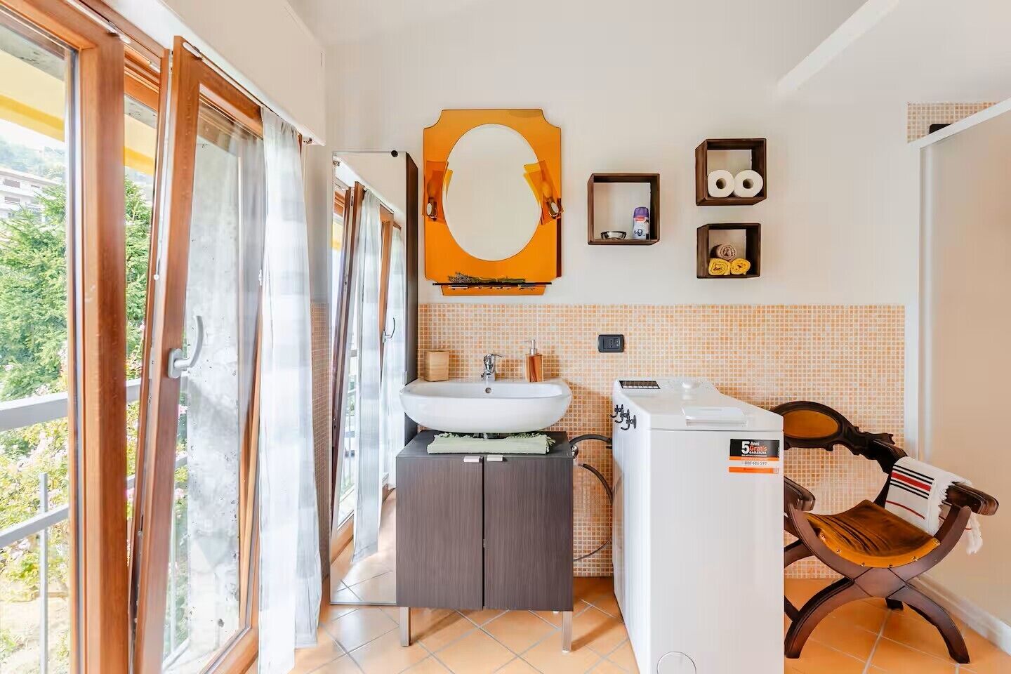 Une salle de bain avec un lavabo, un miroir et un porte-serviettes.