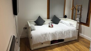 Makuuhuoneessa on sänky, seinälle asennettu televisio, peili ja tikkaat.