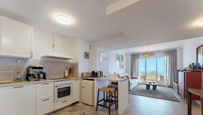 A modern kitchen with a central island, a dining area with a view, and a living space with a balcony. - Relaxing Sea View Escape in Calahonda (Mijas Costa)