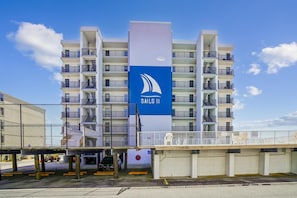 Ein mehrstöckiges Gebäude mit einem auffälligen Segelboot-Logo und der Aufschrift 'SAILS II' an der Fassade.