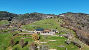 A large building complex with multiple structures, surrounded by green fields and hills. - Domaine Le H - A Destination at the Peak of Your Dreams (Hohrod)