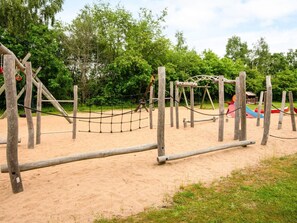 Ein Spielplatz mit Holzkonstruktionen und einer Seilnetz