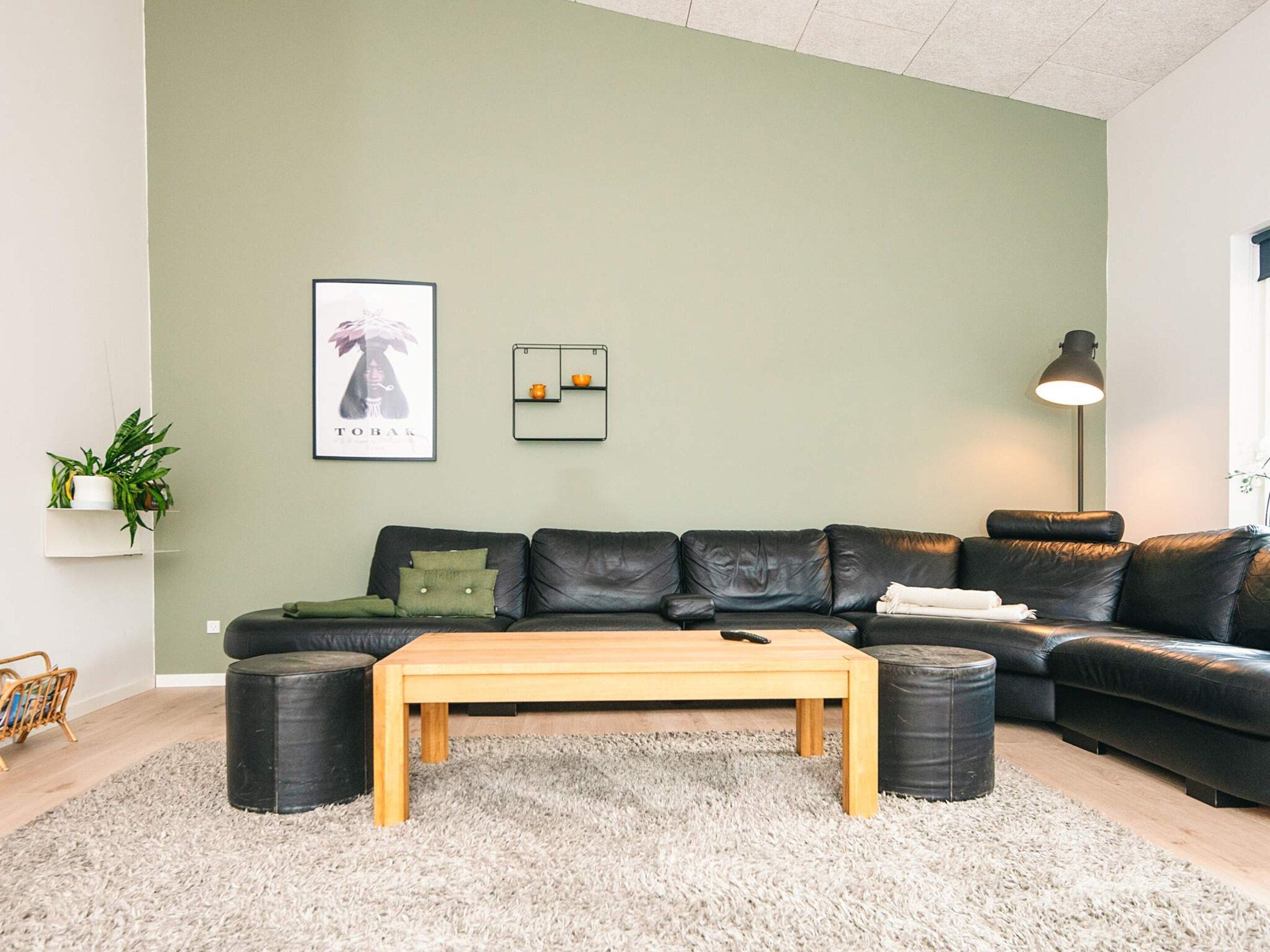 A modern living room with a sectional sofa, a wooden coffee table, and a small side table.