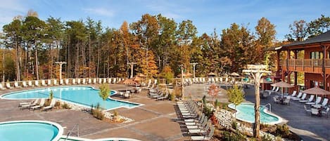 A resort with multiple swimming pools, lounge areas, and a wooden building.