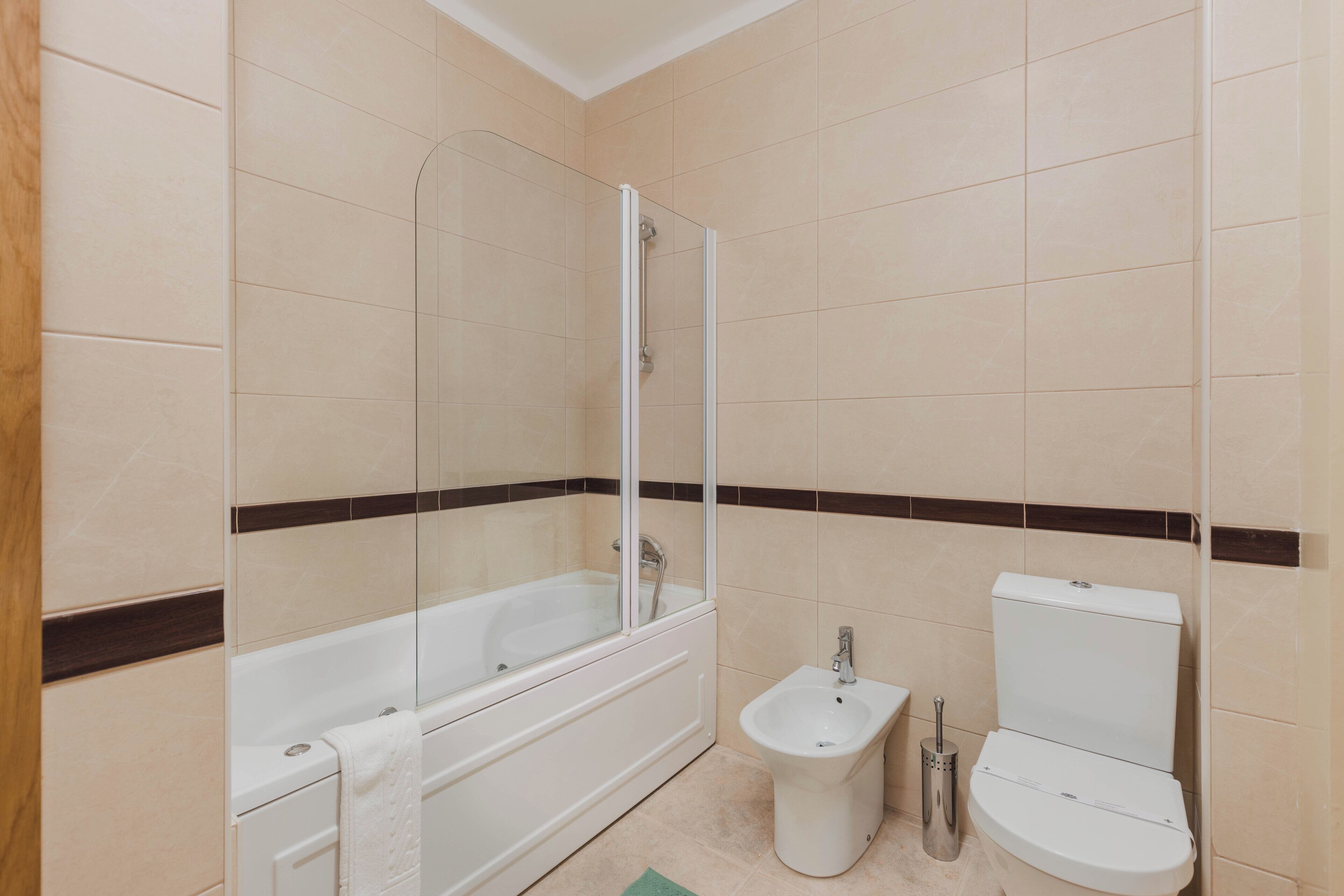 Un baño con bañera, ducha, bidé e inodoro.
