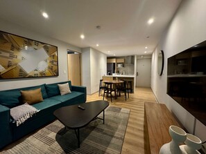 Ein modernes Wohnzimmer mit einer Couch, einem Couchtisch und einem Essbereich mit Stühlen und einem Tisch.