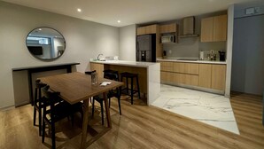 A modern kitchen with wooden cabinets, a stainless steel refrigerator, and a microwave. - w Appealing 1BR w AC in the Heart of Roma Sur (Mexico City)
