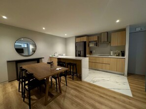 A modern kitchen with wooden cabinets, a stainless steel refrigerator, and a microwave. - w Appealing 1BR w AC in the Heart of Roma Sur (Mexico City)