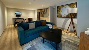 A modern living room with a teal sofa, a black coffee table, and a floor lamp. - w Appealing 1BR w AC in the Heart of Roma Sur (Mexico City)