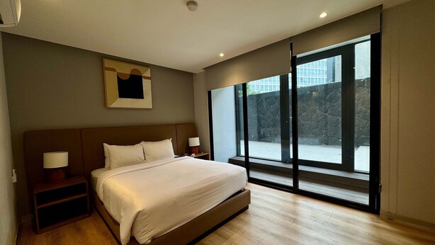 A modern bedroom with a large bed, bedside tables, a window, and a view of the outside. - w Appealing 1BR w AC in the Heart of Roma Sur (Mexico City)