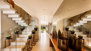 Ein modernes Interieur mit Treppe, Glastrennwand und Topfpflanzen.