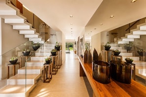 Ein modernes Interieur mit Treppe, Glastrennwand und Topfpflanzen.